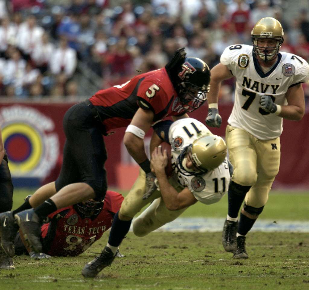 Navy quarterback Craig Candeto is tackled by Texas Tech linebacker John ...