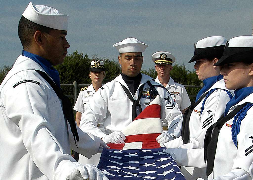 Sailors fold the American flag during Cdr. Michael Woelker s retirement ...