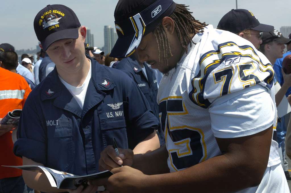 Offensive Tackle for the National Football League (NFL) San Diego Chargers,  Leander Jordan (75), signs an autograph for Aviation Electrician's Mate 3rd  Class Jerimy Holt during a visit aboard USS Ronald Reagan (