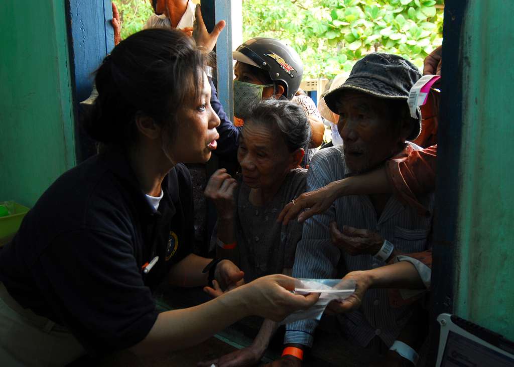 Lt. Cmdr. Cha Vu istributes medicine to local Vietnamese patients