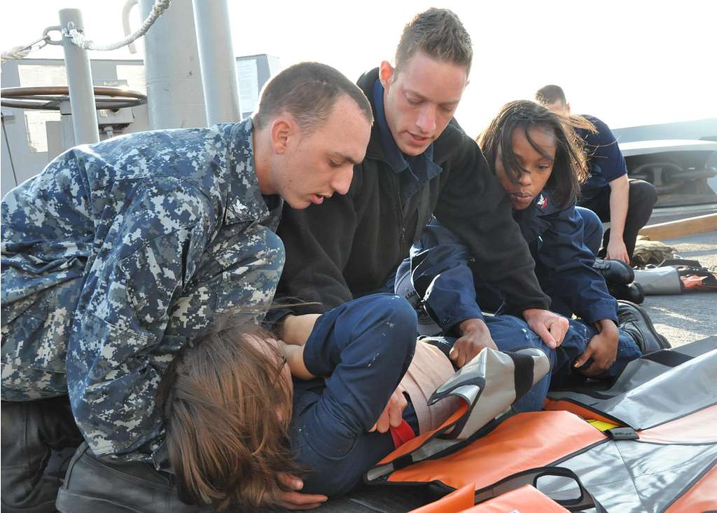 Stretcher bearers and medical personnel aboard the amphibious transport ...