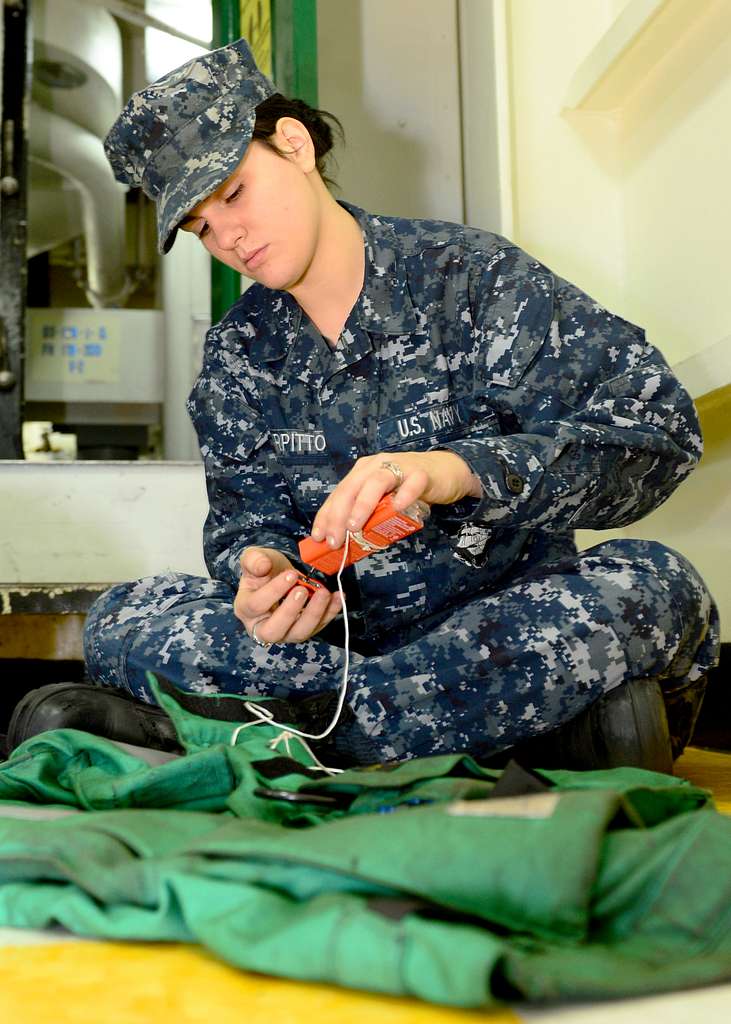 Offensive Tackle for the National Football League (NFL) San Diego Chargers,  Leander Jordan (75), signs an autograph for Aviation Electrician's Mate 3rd  Class Jerimy Holt during a visit aboard USS Ronald Reagan (