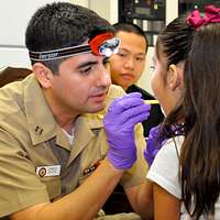 LT. Hoeger, a Navy doctor, listens to Harvey Mitchell's breathing